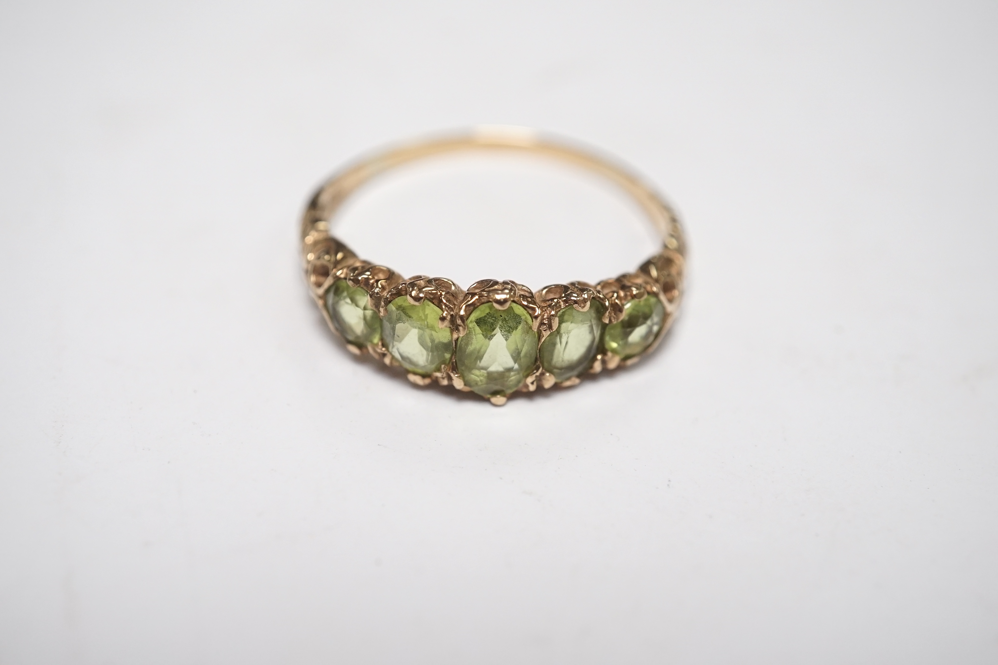 A 9ct and graduated five stone peridot set half hoop ring, size V, a 9ct gold and cameo shell ring and a gem set stickpin. Condition - poor to fair